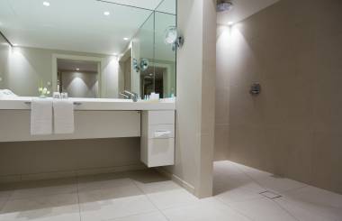 stilvolles Hotel-Badezimmer mit begehbarer Dusche und Spiegelwand